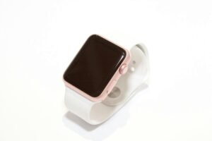 Stylish rose gold smart watch with a white band on a minimalist white background.
